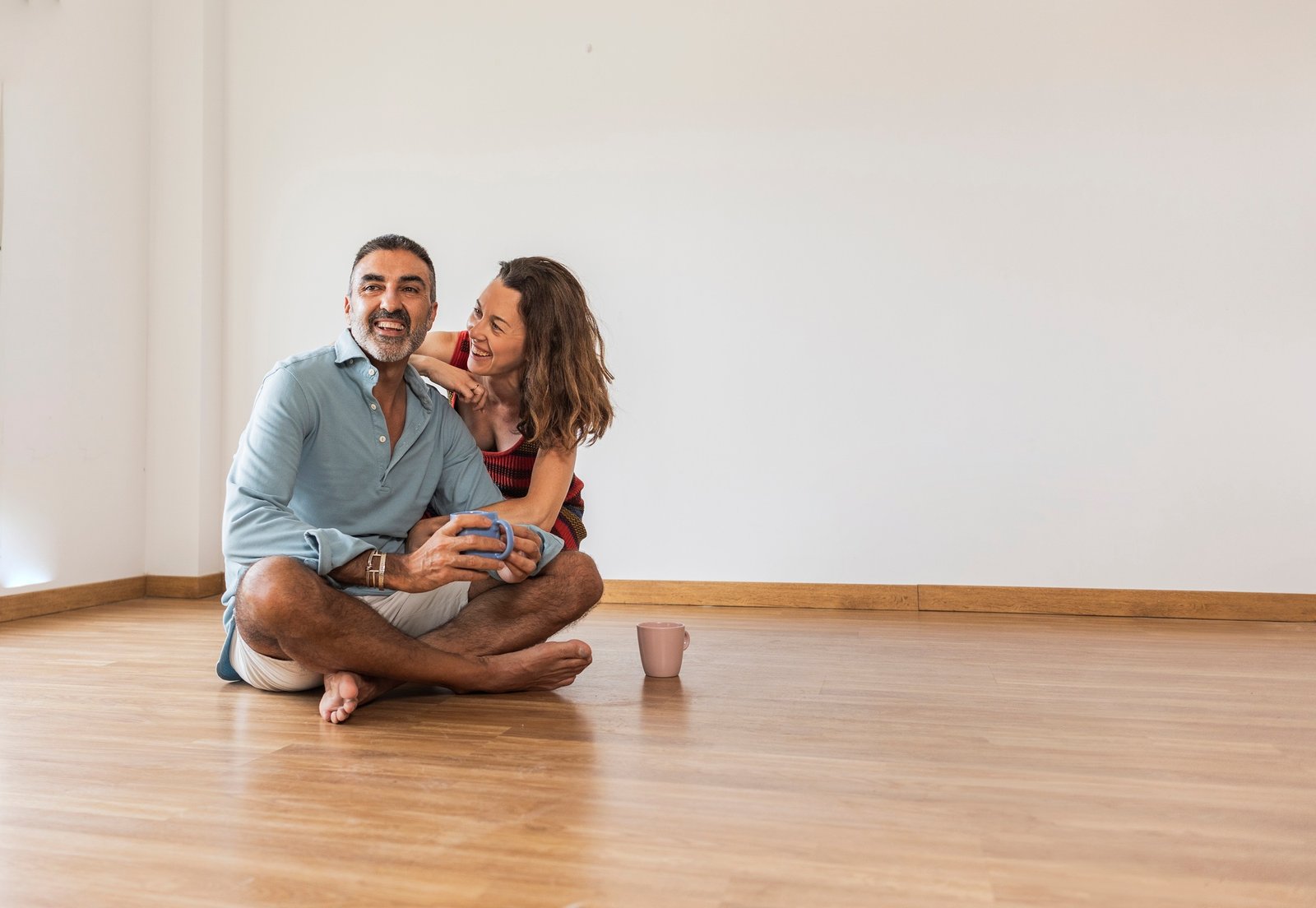 mature couple in an empty house drinking coffee, buying a home, moving.